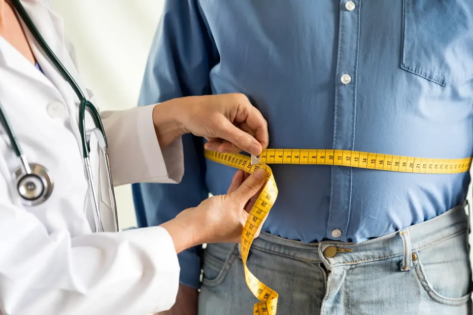 Provider measuring a patient's waist during a weight loss consultation