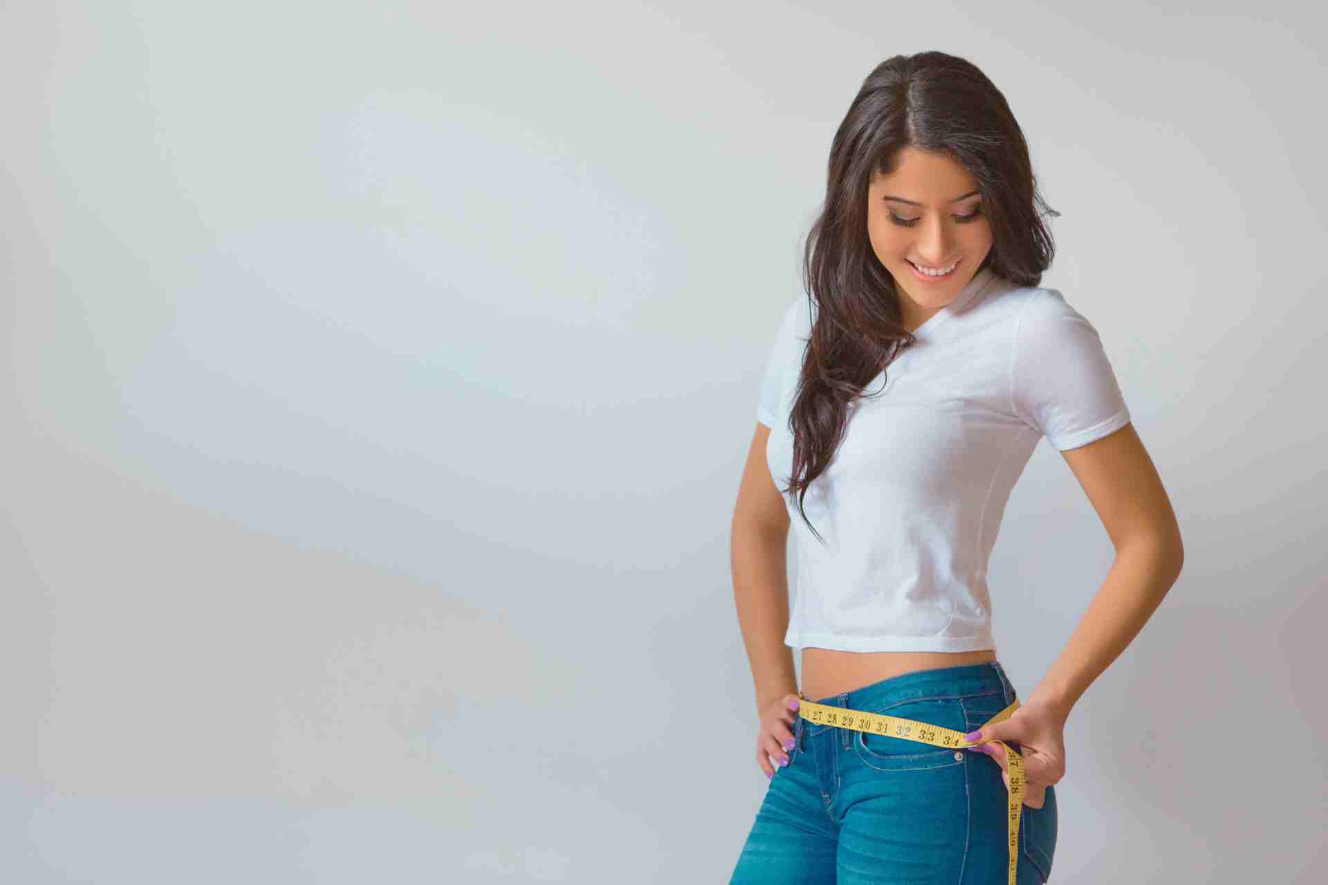Woman measuring her waist.